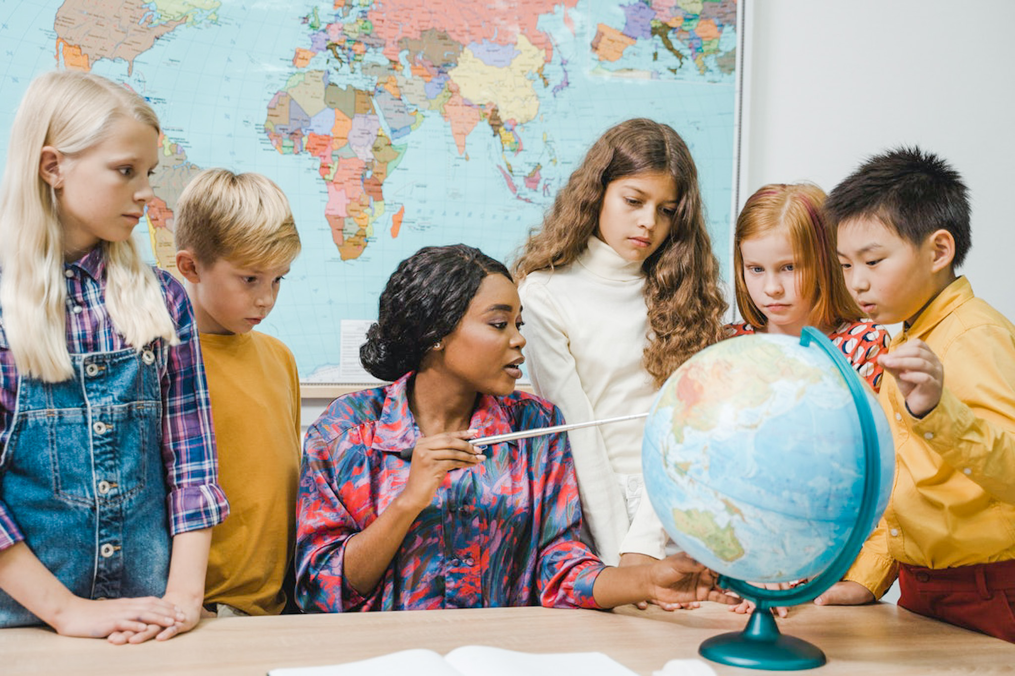 Fiatal tanárnő a diákjaival a földgömböt tanulmányozza. A Gondolkodás Világnapja - Így megy hatékonyabban a tanulás és a gondolkodás