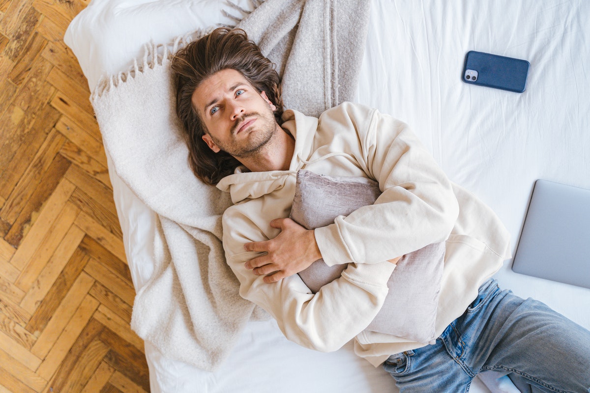 Ágyon fekvő férfi. Az alacsony tesztoszteronszint és a megnövekedett férfi mell közötti összefüggés